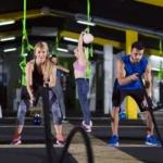 Image displaying a gym with people working out at some type of gym