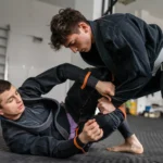 Image of two Brazilian Jiu-Jitsu athletes, including a member with a brown bjj belt rank
